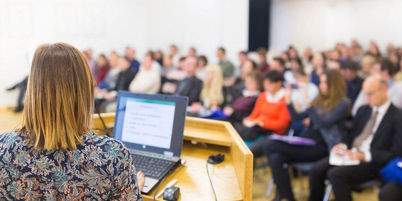 Header-back-of-woman-public-speaking-SS-3573.max-800x600