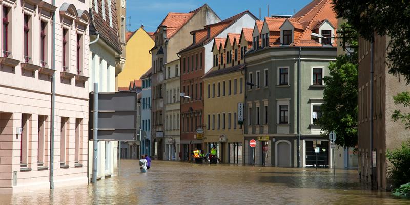 Street flooding in a European city with historic architecture under a sunny sky: Cash is king in a crisis