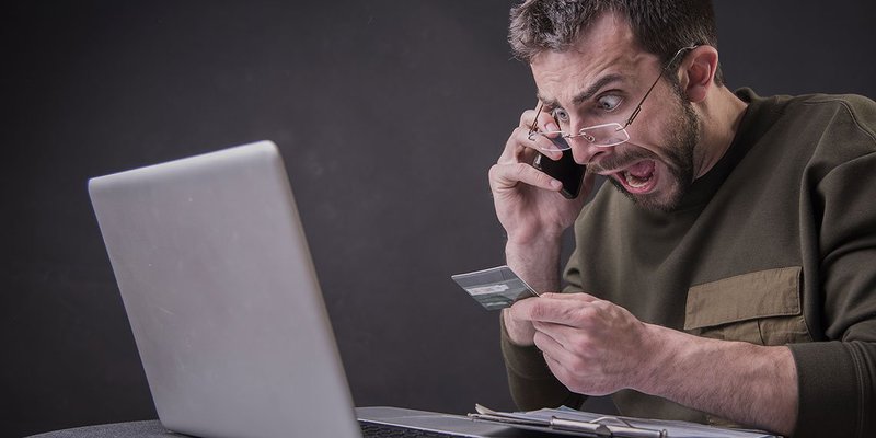 Man angry laptop phone wide